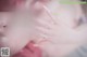 A woman with long white nails is getting her nails done.