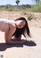 A woman in a white dress laying on the ground.